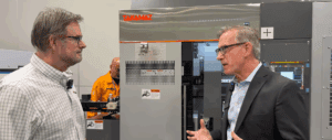 Chris Burd talking to Andrew Hecker next to the Takamaz XT-6M automated turning CNC lathe.
